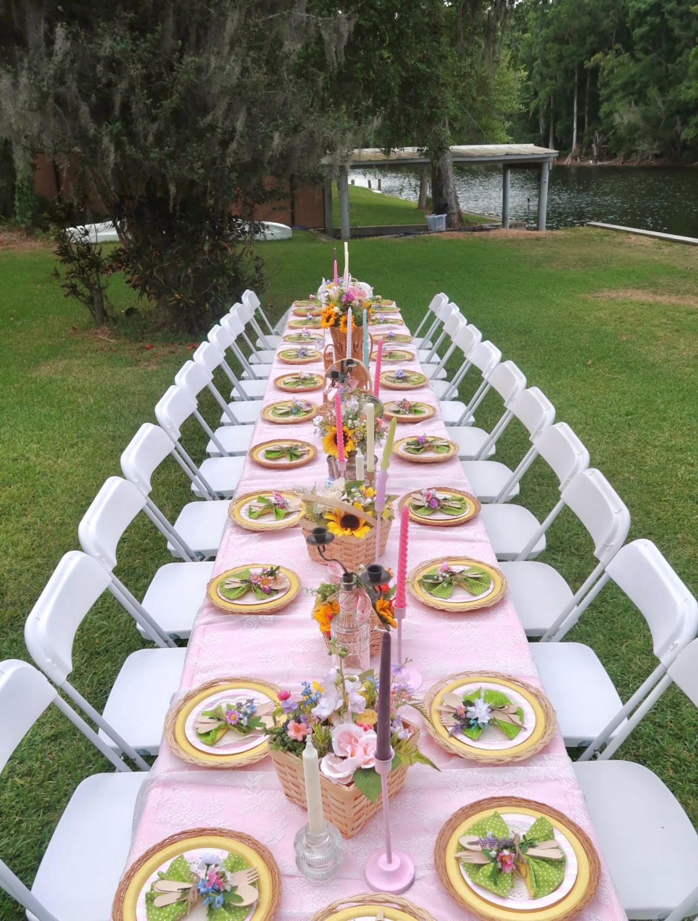 Long rental table with white folding chairs styled for a lakeside garden party in Pasco County
